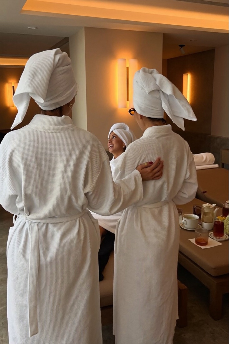 A group of friends in robes laughing in the lounge